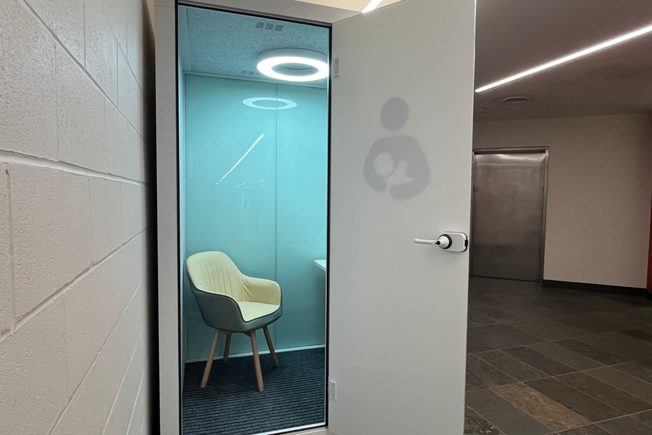 An image of the private lactation pod - a chair, shelf, and mirror inside a large pod, or box 